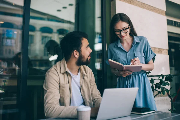 Vidám Fiatal Alkalmi Ruhát Mosolyog Írás Notebook Miközben Áll Közel — Stock Fotó