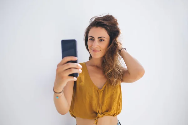 여름의 아름다운 여성은 배경에 머리카락을 스마트폰으로 사진을 — 스톡 사진