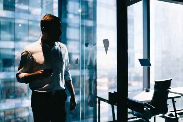 Jonge Intelligente Mannelijke Werknemer Met Mobiele Apparaat Staan Het Kantoor — Stockfoto