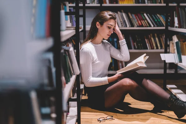 在图书馆里 智力聪明的女人 黑发长发 休闲装 坐在地板上看书 — 图库照片