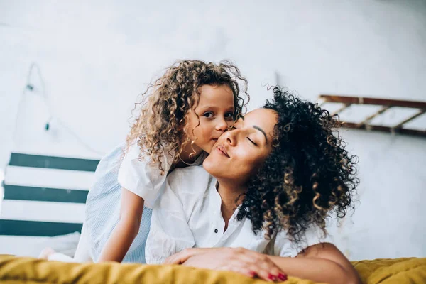 Adorável Criança Abraçando Beijando Bochecha Mulher Alegre Étnica Com Penteado — Fotografia de Stock