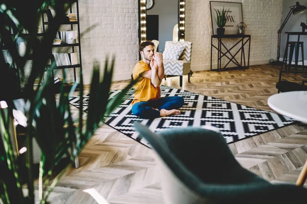 Hombre Joven Enfocado Camisa Naranja Pantalones Azules Haciendo Yoga Posa —  Fotos de Stock