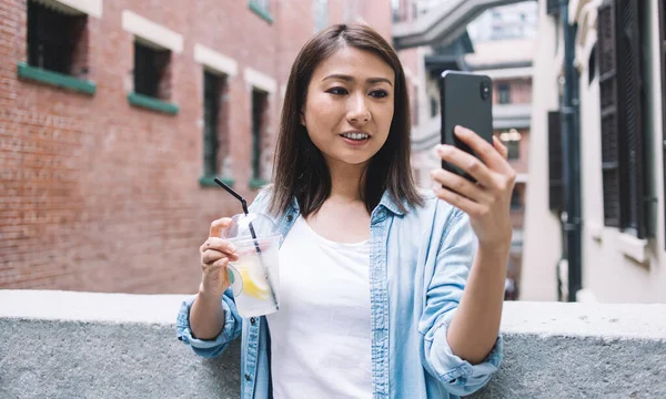 Szczęśliwa Azjatka Modnej Kurtce Jeansowej Robi Selfie Pije Lemoniadę Uśmiechając — Zdjęcie stockowe