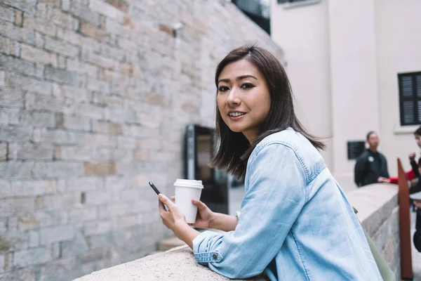 Lässig Trendy Erfreut Junge Asiatin Mit Kaffeetasse Zum Mitnehmen Sms — Stockfoto