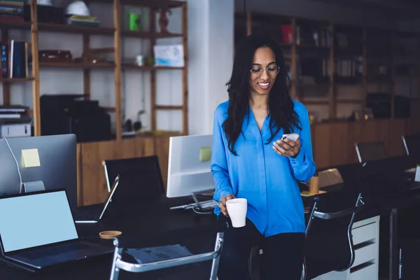 Empresária Afro Americana Sorrindo Mensagens Smartphone Carregando Copo Mão Enquanto — Fotografia de Stock