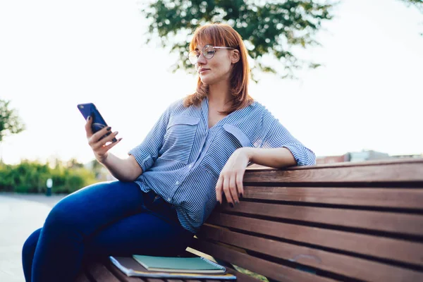 Mujer Milenaria Caucásica Positiva Gafas Viendo Video Teléfono Móvil Sentado —  Fotos de Stock