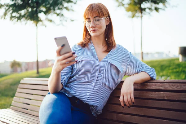Gözlüklü Çekici Kızıl Kadın Parkta Boş Zamanlarında Cep Telefonu Kullanarak — Stok fotoğraf