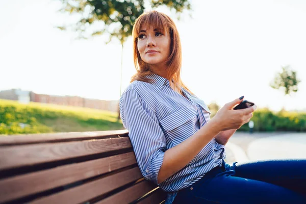 Modern Akıllı Telefon Kullanarak Parktaki Bankta Dinlenen Beyaz Çekici Kadın — Stok fotoğraf