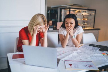 Mutsuz genç bir bayan, fırında ağzını kapatan ve etnik olarak hayal kırıklığına uğramış bir kadınla iş birliği yapmaya çalışıyor.