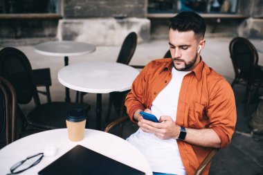 Kapalı dizüstü bilgisayarın önünde oturan başarılı bir serbest yazar yuvarlak masa üzerinde oturuyor ve kahve molası sırasında sosyal medyada sohbet ediyor. 