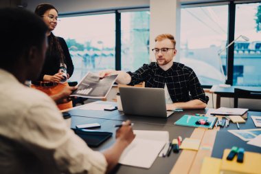 Gündelik olarak çalışan çeşitli erkek ve kadınlar okul ödevlerinde işbirliği yapıyor evrak işlerinden gelen bilgileri kontrol ediyorlar, yeni nesil Z öğrencileri iş projesi oluşturmak için çalışma alanında brifing veriyorlar.