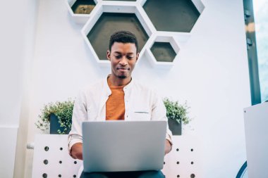 Modern dizüstü bilgisayarda 4G kablosuz internet kullanan koyu tenli erkek programcı IT profesyonelleri için web platformu geliştiriyor, Afrikalı Amerikalı adam sosyal medyum ağlarıyla iletişim kuruyor