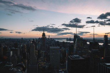 Manhattan 'ın merkezindeki gökdelenlerin ve kulelerin gökyüzü manzarası. Akşam günbatımında gökyüzü. Finansal bölgenin manzarası ünlü New York simgesi, aydınlanmış Empire State Binası