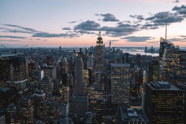 Manhattan 'ın merkezindeki gökdelenlerin ve kulelerin gökyüzü manzarası. Akşam günbatımında gökyüzü. Finansal bölgenin manzarası ünlü New York simgesi, aydınlanmış Empire State Binası