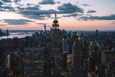 Manhattan 'ın merkezindeki gökdelenlerin ve kulelerin gökyüzü manzarası. Akşam günbatımında gökyüzü. Finansal bölgenin manzarası ünlü New York simgesi, aydınlanmış Empire State Binası
