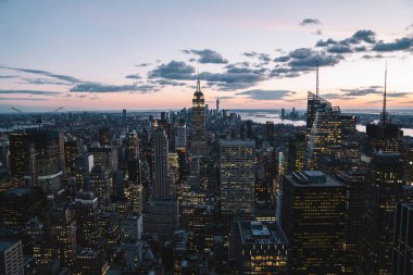Manhattan 'ın merkezindeki gökdelenlerin ve kulelerin gökyüzü manzarası. Akşam günbatımında gökyüzü. Finansal bölgenin manzarası ünlü New York simgesi, aydınlanmış Empire State Binası