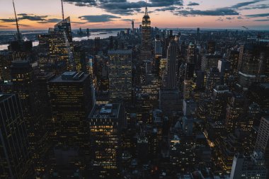 Manhattan 'ın merkezindeki gökdelenlerin ve kulelerin gökyüzü manzarası. Akşam günbatımında gökyüzü. Finansal bölgenin manzarası ünlü New York simgesi, aydınlanmış Empire State Binası