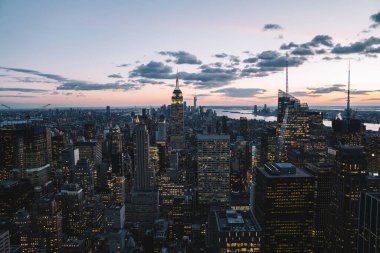 Manhattan 'ın merkezindeki gökdelenlerin ve kulelerin gökyüzü manzarası. Akşam günbatımında gökyüzü. Finansal bölgenin manzarası ünlü New York simgesi, aydınlanmış Empire State Binası
