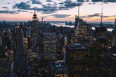 Manhattan 'ın merkezindeki gökdelenlerin ve kulelerin gökyüzü manzarası. Akşam günbatımında gökyüzü. Finansal bölgenin manzarası ünlü New York simgesi, aydınlanmış Empire State Binası