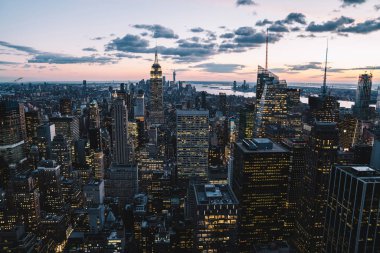 Manhattan 'ın merkezindeki gökdelenlerin ve kulelerin gökyüzü manzarası. Akşam günbatımında gökyüzü. Finansal bölgenin manzarası ünlü New York simgesi, aydınlanmış Empire State Binası