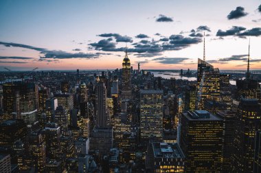 Manhattan 'ın merkezindeki gökdelenlerin ve kulelerin gökyüzü manzarası. Akşam günbatımında gökyüzü. Finansal bölgenin manzarası ünlü New York simgesi, aydınlanmış Empire State Binası
