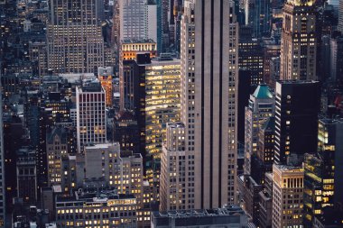 Manhattan 'ın çeşitli yüksek gökdelenlerinin gökdelenlerinin gökdelenleri. New York' ta akşam saatlerinde pencereleri açık olan binalar. Metropolis 'in gece hayatı, ofisler ve gayrimenkul. Şehir merkezindeki yapılar