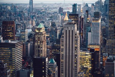 Manhattan 'ın çeşitli yüksek gökdelenlerinin gökdelenlerinin gökdelenleri. New York' ta akşam saatlerinde pencereleri açık olan binalar. Metropolis 'in gece hayatı, ofisler ve gayrimenkul. Şehir merkezindeki yapılar