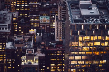 Akşam saatlerinde New York 'ta ışıklı pencereli gökdelen manzaralı bir bina. Metropolis 'in gece hayatı, ofisler ve gayrimenkul. Şehir merkezi yapısı