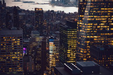 Manhattan 'ın çeşitli yüksek gökdelenlerinin gökdelenlerinin gökdelenleri. New York' ta akşam saatlerinde pencereleri açık olan binalar. Metropolis 'in gece hayatı, ofisler ve gayrimenkul. Şehir merkezindeki yapılar