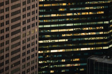 Manhattan 'ın çeşitli yüksek gökdelenlerinin gökdelenlerinin gökdelenleri. New York' ta akşam saatlerinde pencereleri açık olan binalar. Metropolis 'in gece hayatı, ofisler ve gayrimenkul. Şehir merkezindeki yapılar