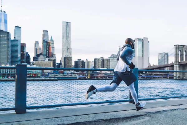 Vista Laterale Del Corridore Maschio Muscoloso Etnico Cuffia Vestiti Sportivi — Foto Stock