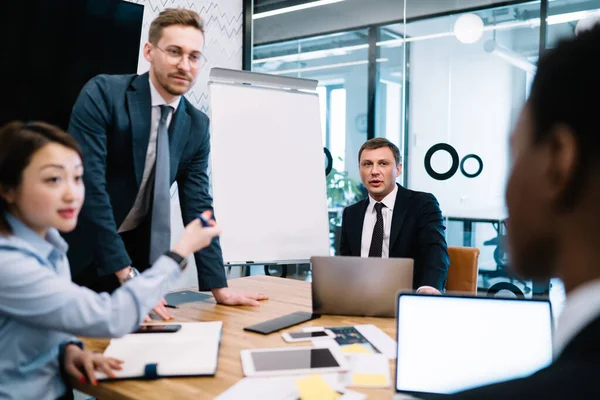 Aufgewühlte Erwachsene Multiethnische Mitarbeiter Eleganter Kleidung Streiten Mit Verschwommenen Gesichtslosen — Stockfoto