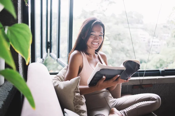 Sorrindo Despreocupado Étnico Feminino Roupas Esportivas Lançando Páginas Livro Sentado — Fotografia de Stock