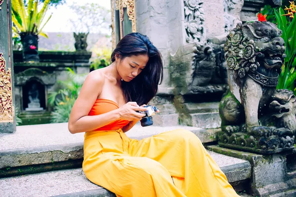 Junge Asiatische Fotografin Stylischer Orangefarbener Kleidung Schaut Durch Aufnahmen Vor — Stockfoto