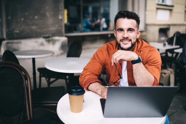 Optimistický Muž Student Neformálním Oblečení Chytrými Hodinkami Pracuje Notebooku Usmívá — Stock fotografie