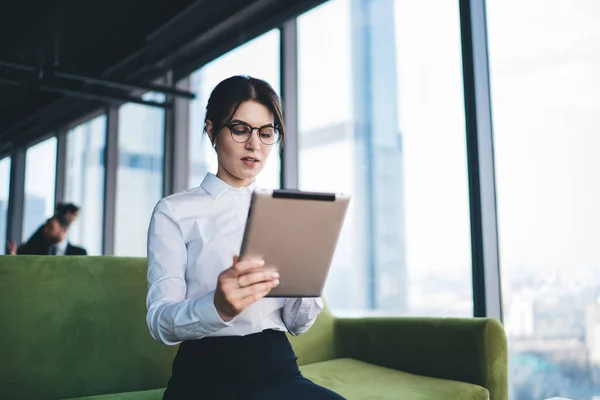 Volwassen Vrouwelijke Werknemer Formele Kleding Glazen Zitten Bank Hal Browsen — Stockfoto