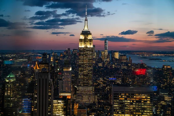 纽约市曼哈顿区的摩天大楼闪烁着光芒 周围都是明亮的建筑 背景是乌云密布的天空 — 图库照片