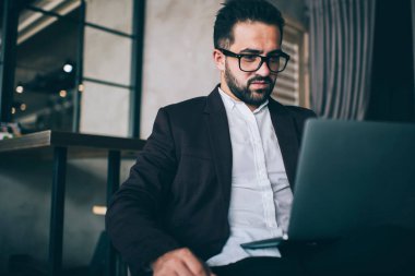 Ciddi bir beyaz erkek avukat göz öngörüsü koruması ve laptop bilgisayarındaki web sayfasından bilgi okumak için resmi kıyafetler, kendinden emin iş adamı mailleri kontrol ediyor ve uzak görevdeki verileri analiz ediyor. 