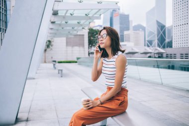 Çekici Çinli kadın turistin kahve ile kentte dinlenmesi, konuşma ve iletişim için mobil çağrı alması, modern teknoloji kavramı ve Z jenerasyonu