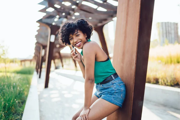 一个快乐的非洲裔美国嬉皮士女孩用4G网络连接在城市公园区打电话的画像 一个快乐的黑皮肤女人在享受智能手机 — 图库照片
