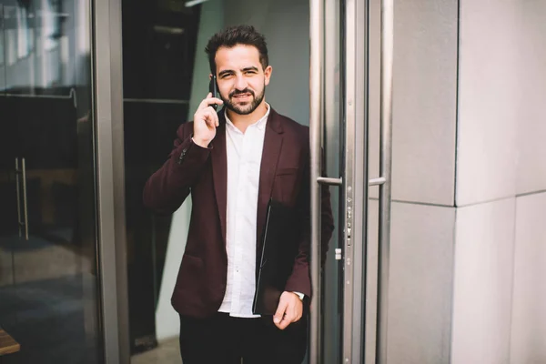 Resmi Ceketli Neşeli Beyaz Erkek Binanın Kapısında Durmuş Cep Telefonuyla — Stok fotoğraf