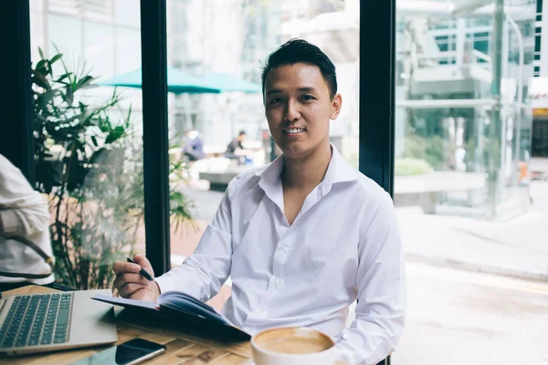 Relaxált Pozitív Ázsiai Férfi Asztal Kávézóban Kávézó Dolgozik Laptop Jegyzettömb — Stock Fotó