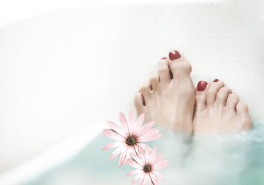 Bir kadın ayakları için kaplıca tedavisi uygular.