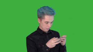 Genç adam duygusal olarak hareketli bir oyun oynuyor. Yeşil ekranda oyunlar oynanıyor.