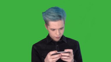 Genç adam duygusal olarak hareketli bir oyun oynuyor. Yeşil ekranda oyunlar oynanıyor.