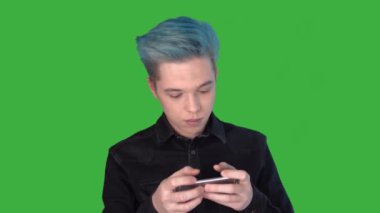 Genç adam duygusal olarak hareketli bir oyun oynuyor. Yeşil ekranda oyunlar oynanıyor.