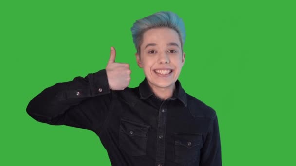 Молодий чоловік з кольоровою посмішкою, що показує, як зелений екран. Гей з кольоровим волоссям — стокове відео