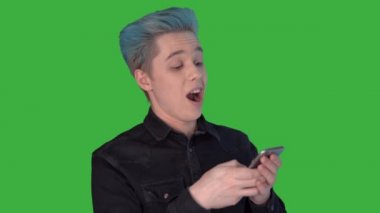 Genç komik adam hevesle gezici bir oyun oynuyor. Duygular. Yeşil Ekran.