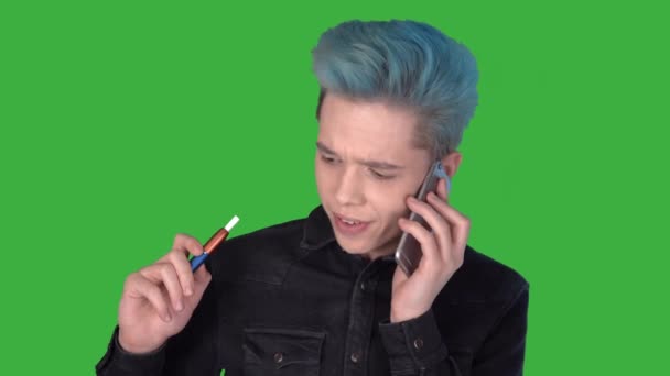 Молодой бизнесмен говорит по телефону курить электронные сигареты iqos зеленый экран — стоковое видео
