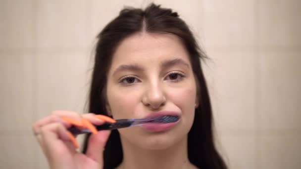 Young woman brushing her teeth with brush and toophpacte closeup — Stock Video